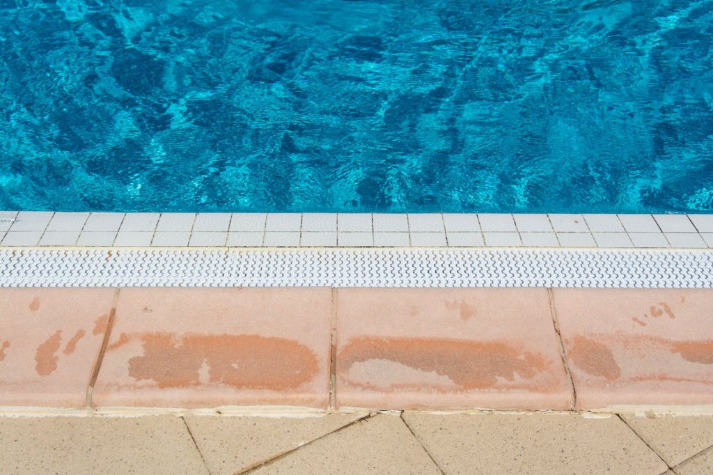 pexels-photo-15508636 A bright image showcasing the inviting edge of a swimming pool under the summer sun.